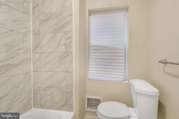 a bathroom with a sink mirror and toilet