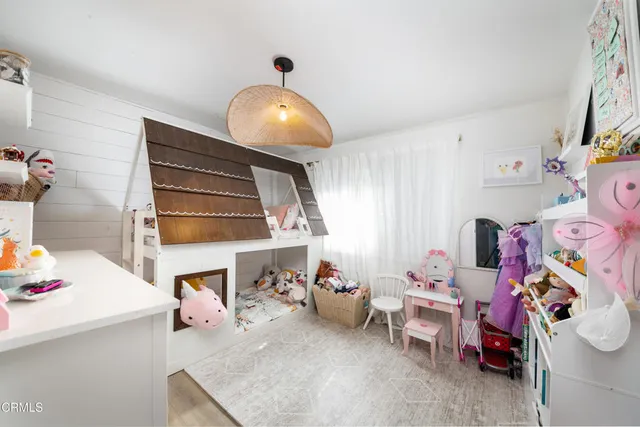 a room with a baby crib and a wooden floor