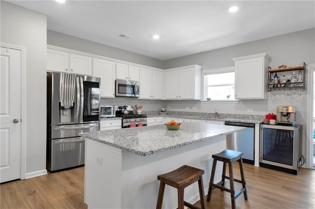 660 Groover Street Ball Ground, GA 30107 - Photo 12 of 53 a kitchen with a white cabinets and stainless steel appliances