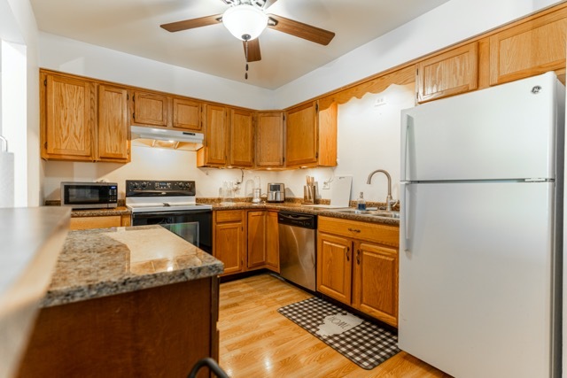 159 West Elk Trail, Unit 357 Carol Stream, IL 60188 - Photo 6 of 10 a kitchen with stainless steel appliances granite countertop a refrigerator a sink dishwasher a stove and white cabinets with wooden floor