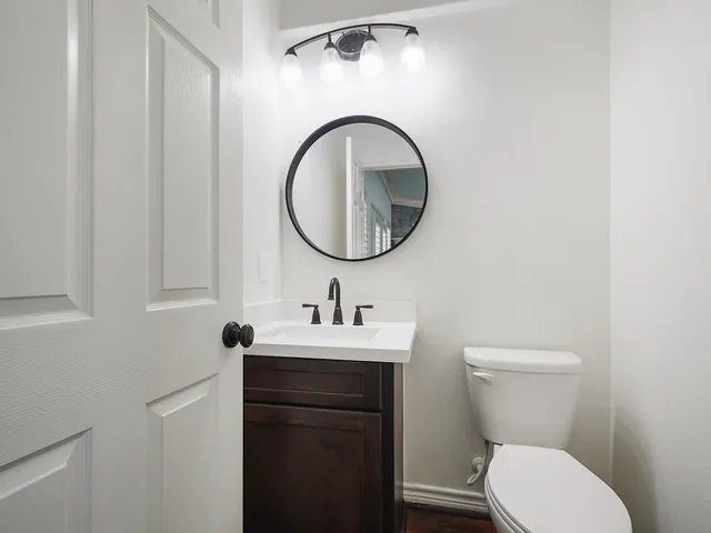 a bathroom with a toilet a sink and a mirror