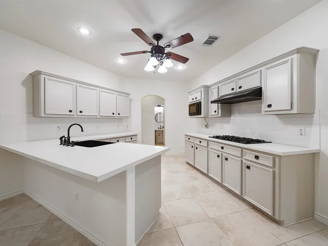 a kitchen with stainless steel appliances granite countertop a sink a stove and a refrigerator