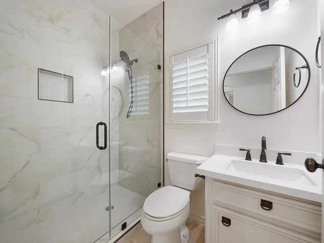 a bathroom with a toilet sink shower and mirror