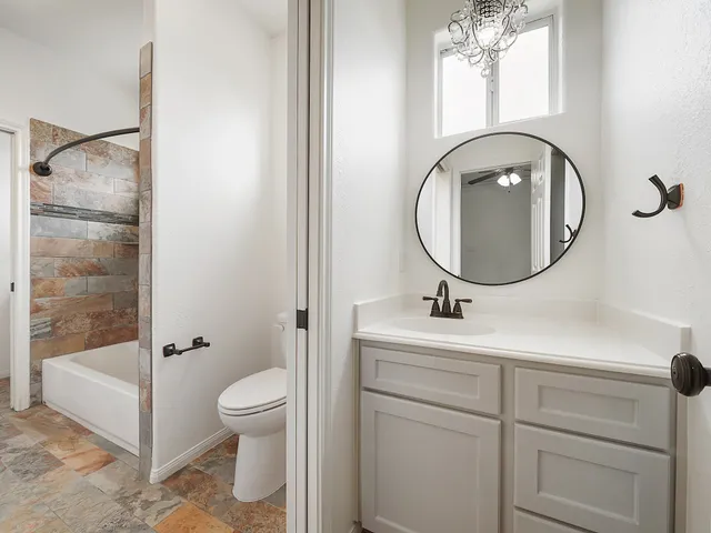 a bathroom with a sink a toilet and a mirror