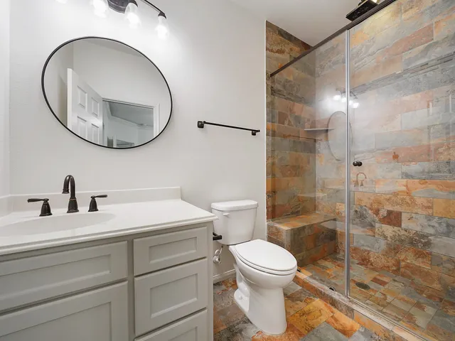 a bathroom with a sink a toilet and a mirror