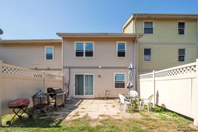 a backyard of a house with table and chairs