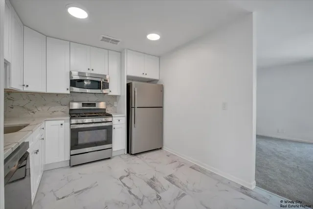 a kitchen with a refrigerator sink and stove top oven