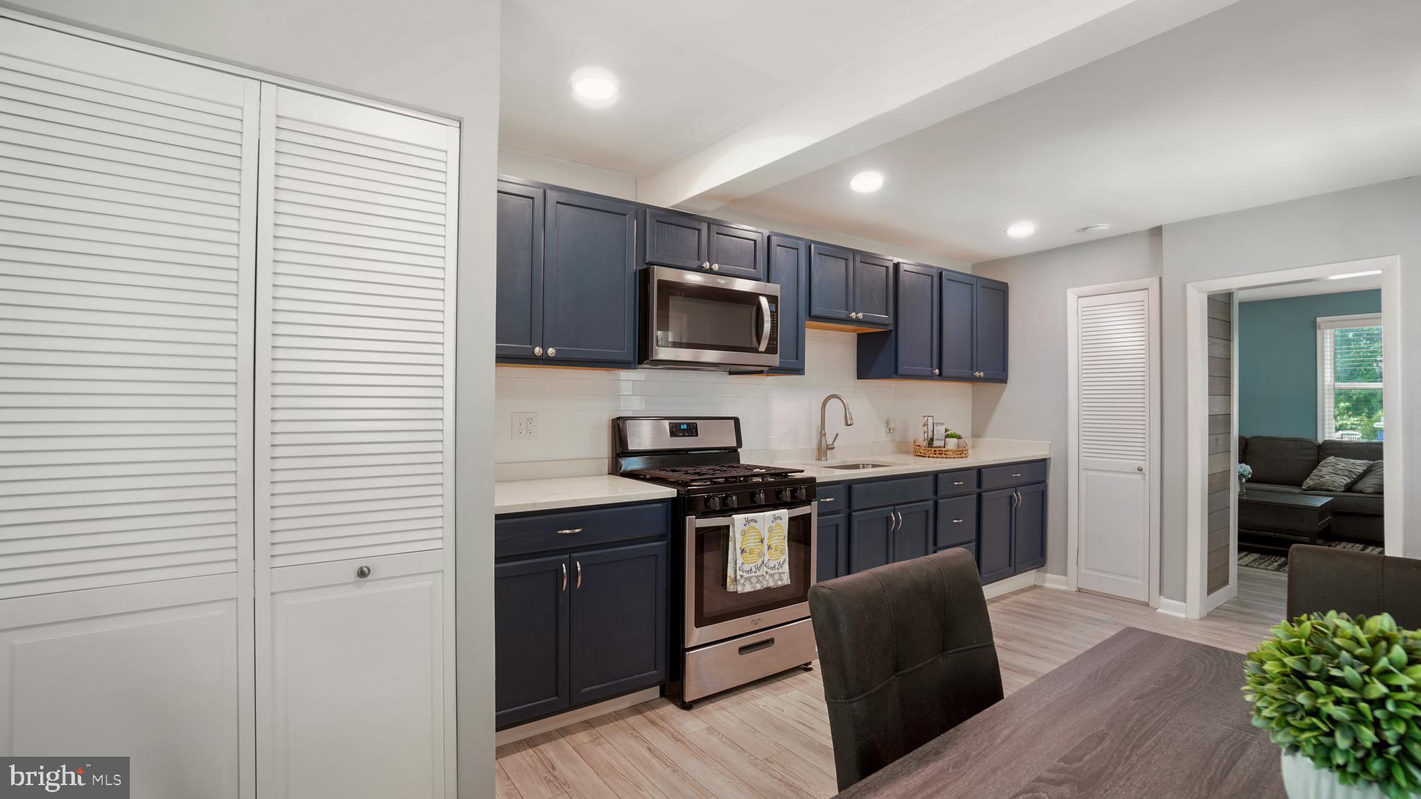 1802 Kitty Hawk Road Baltimore, MD 21221 - Photo 9 of 22 a kitchen with stainless steel appliances granite countertop a refrigerator a stove top oven a sink dishwasher and wooden cabinets