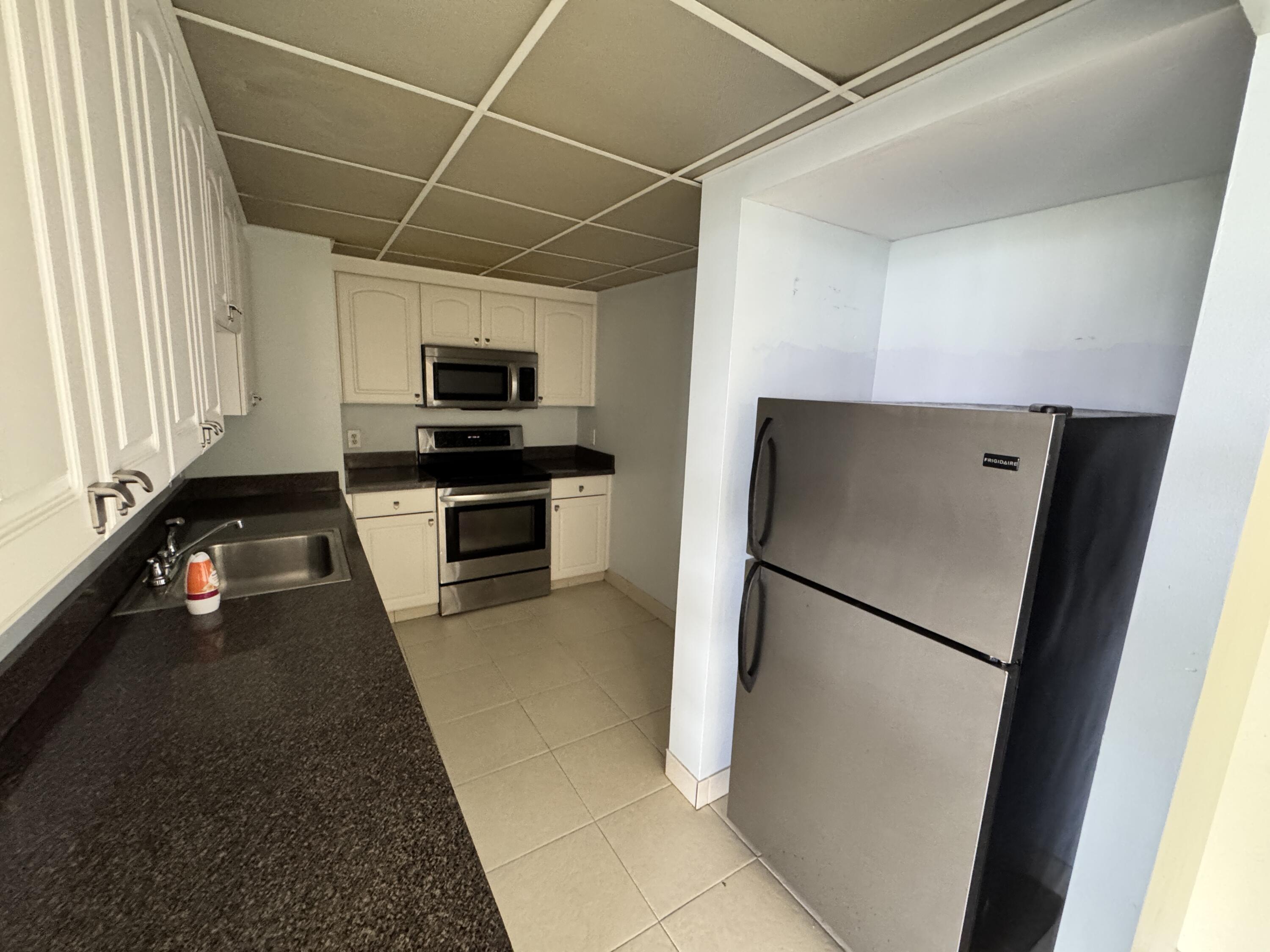 5600 North Flagler Drive, Unit 906 West Palm Beach, FL 33407 - Photo 11 of 18 a kitchen with a refrigerator and a sink