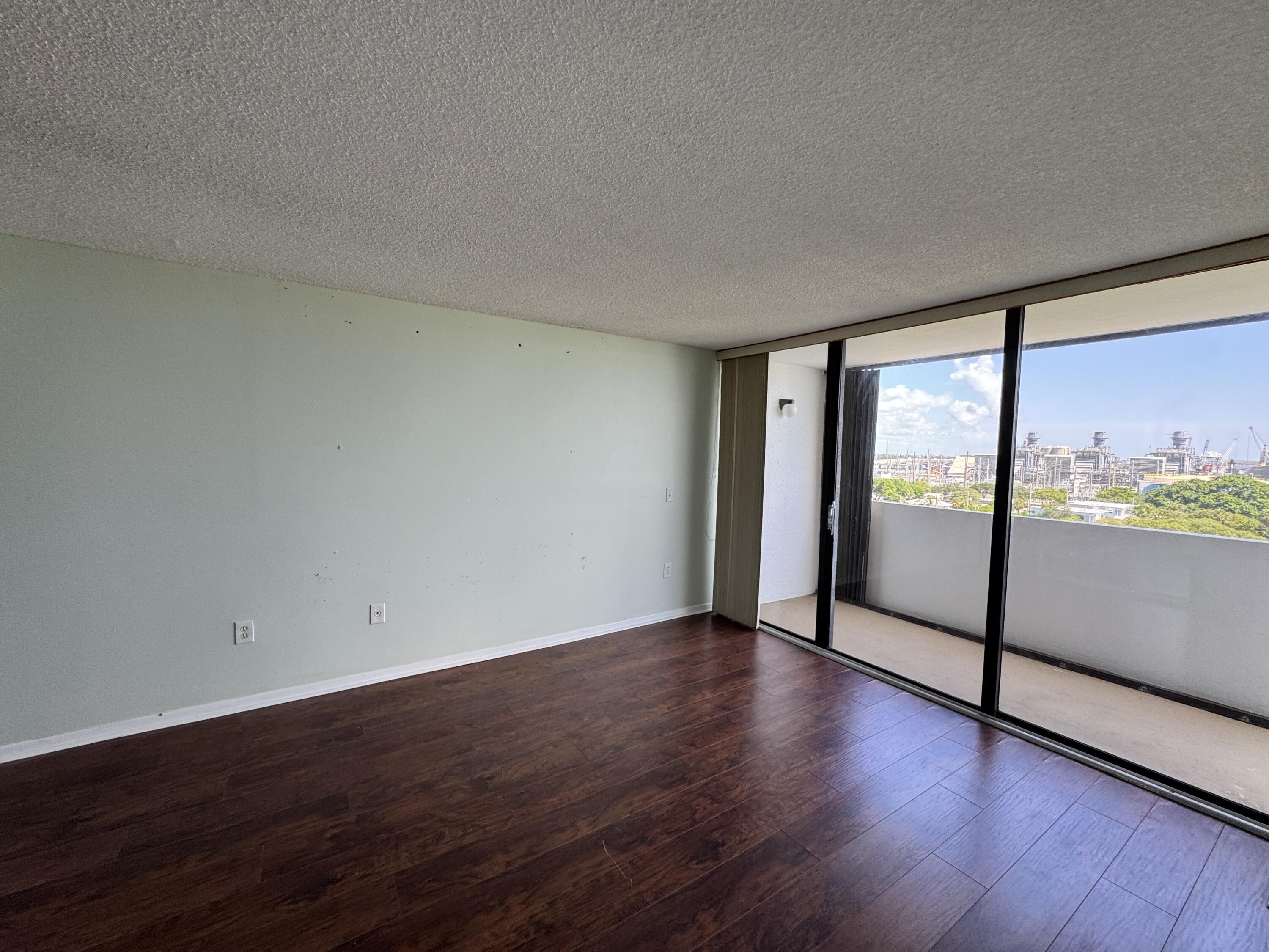 5600 North Flagler Drive, Unit 906 West Palm Beach, FL 33407 - Photo 13 of 18 a view of an empty room with wooden floor and a window