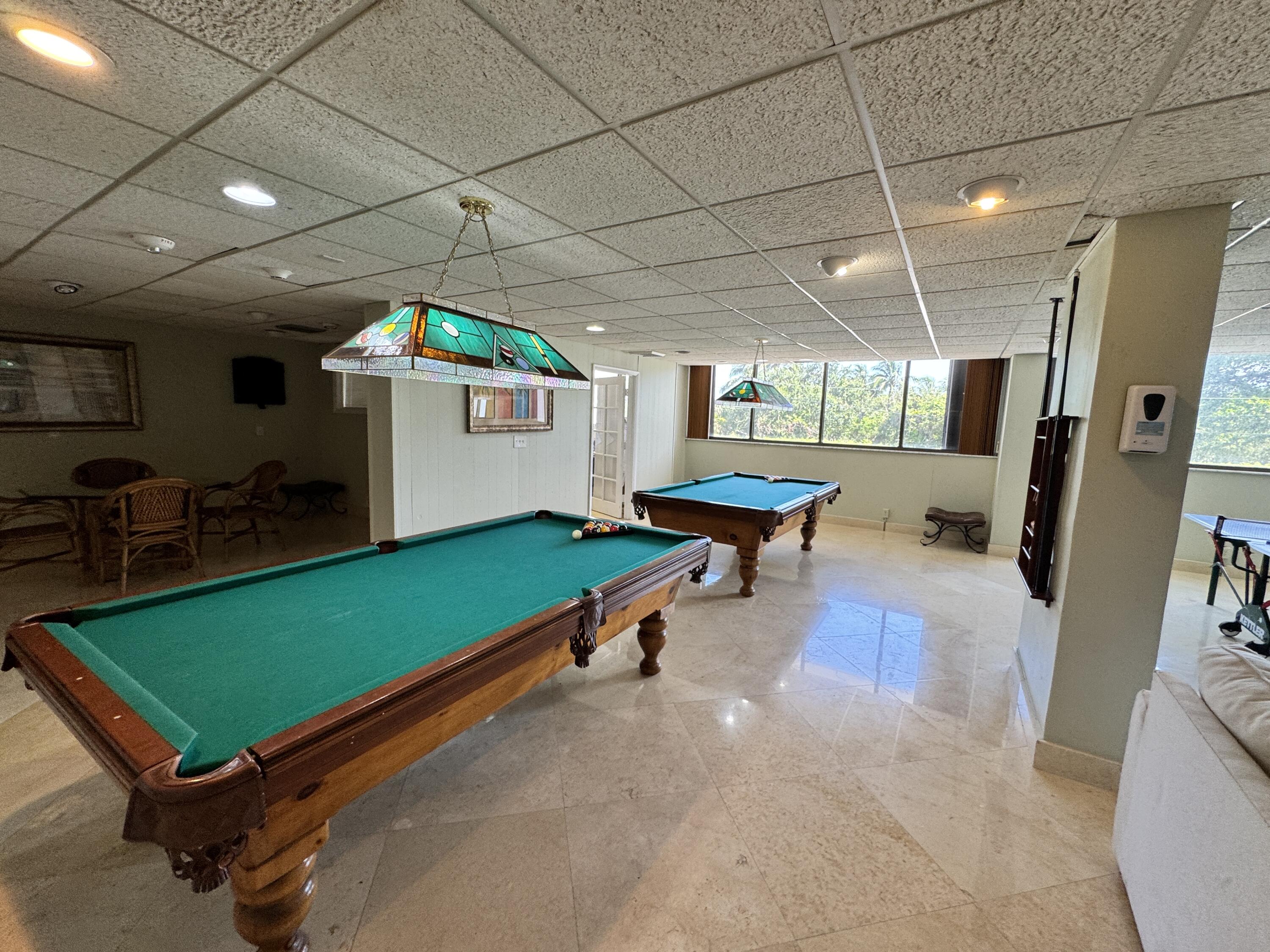 5600 North Flagler Drive, Unit 906 West Palm Beach, FL 33407 - Photo 17 of 18 a room with furniture pool table wooden floor and windows