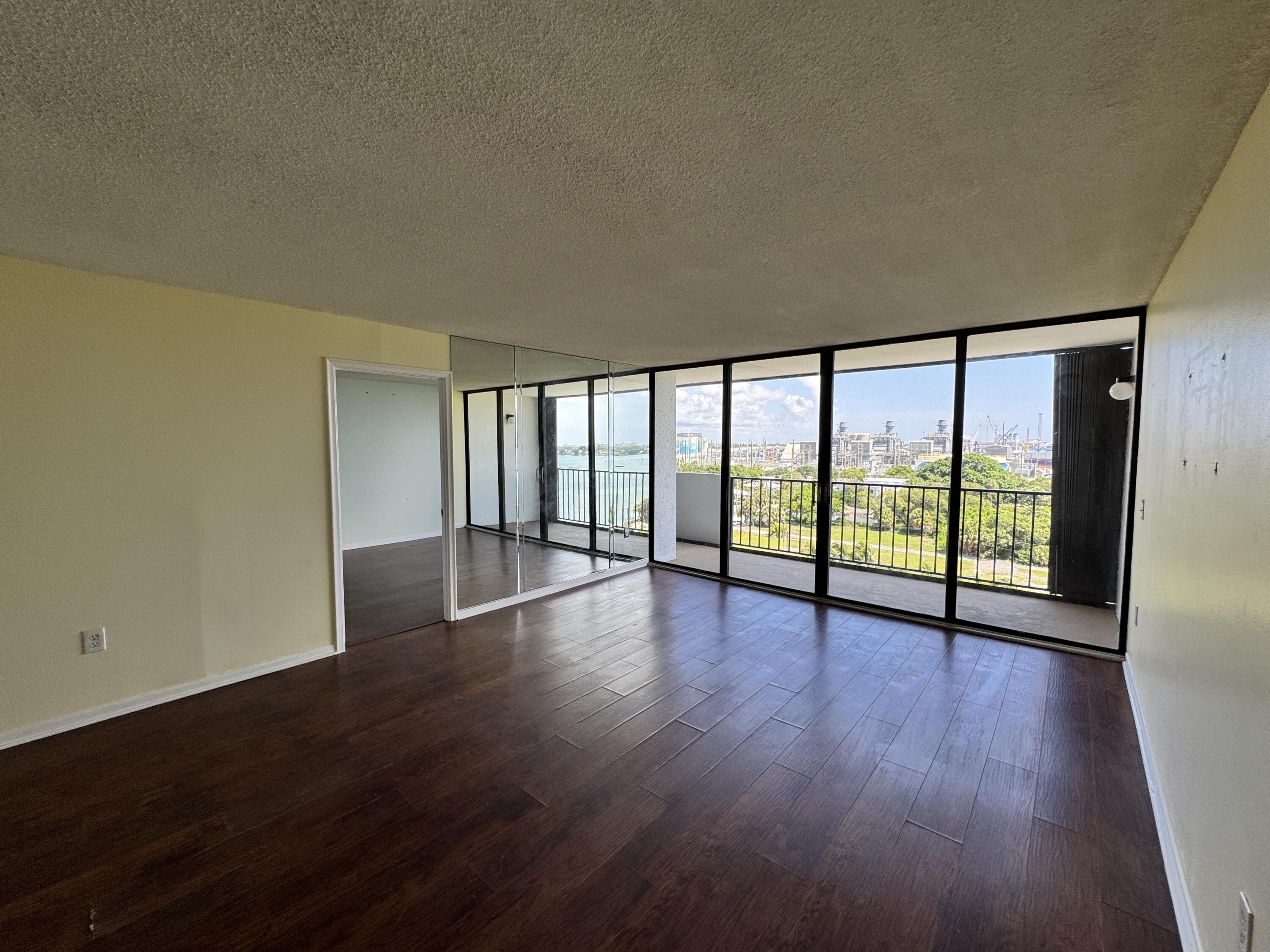 5600 North Flagler Drive, Unit 906 West Palm Beach, FL 33407 - Photo 9 of 18 a view of an empty room with wooden floor and a window