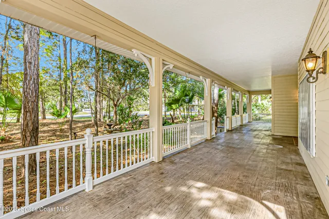a view of hallway with a large window and wooden floor