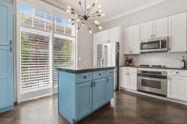 a kitchen with stainless steel appliances granite countertop a stove a sink and a microwave