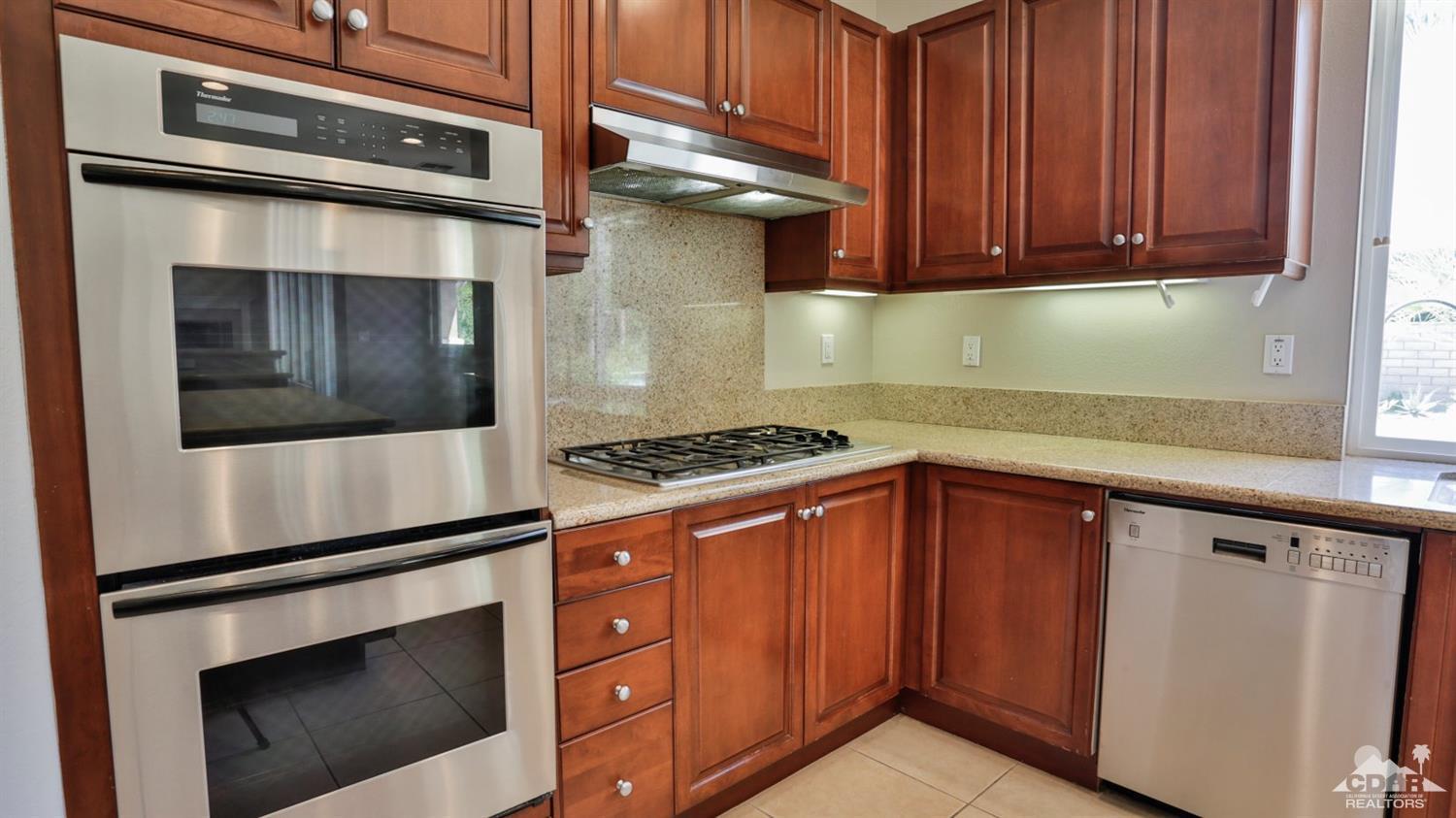 5 University Circle Rancho Mirage, CA 92270 - Photo 13 of 60 a kitchen with stainless steel appliances granite countertop a stove and a microwave