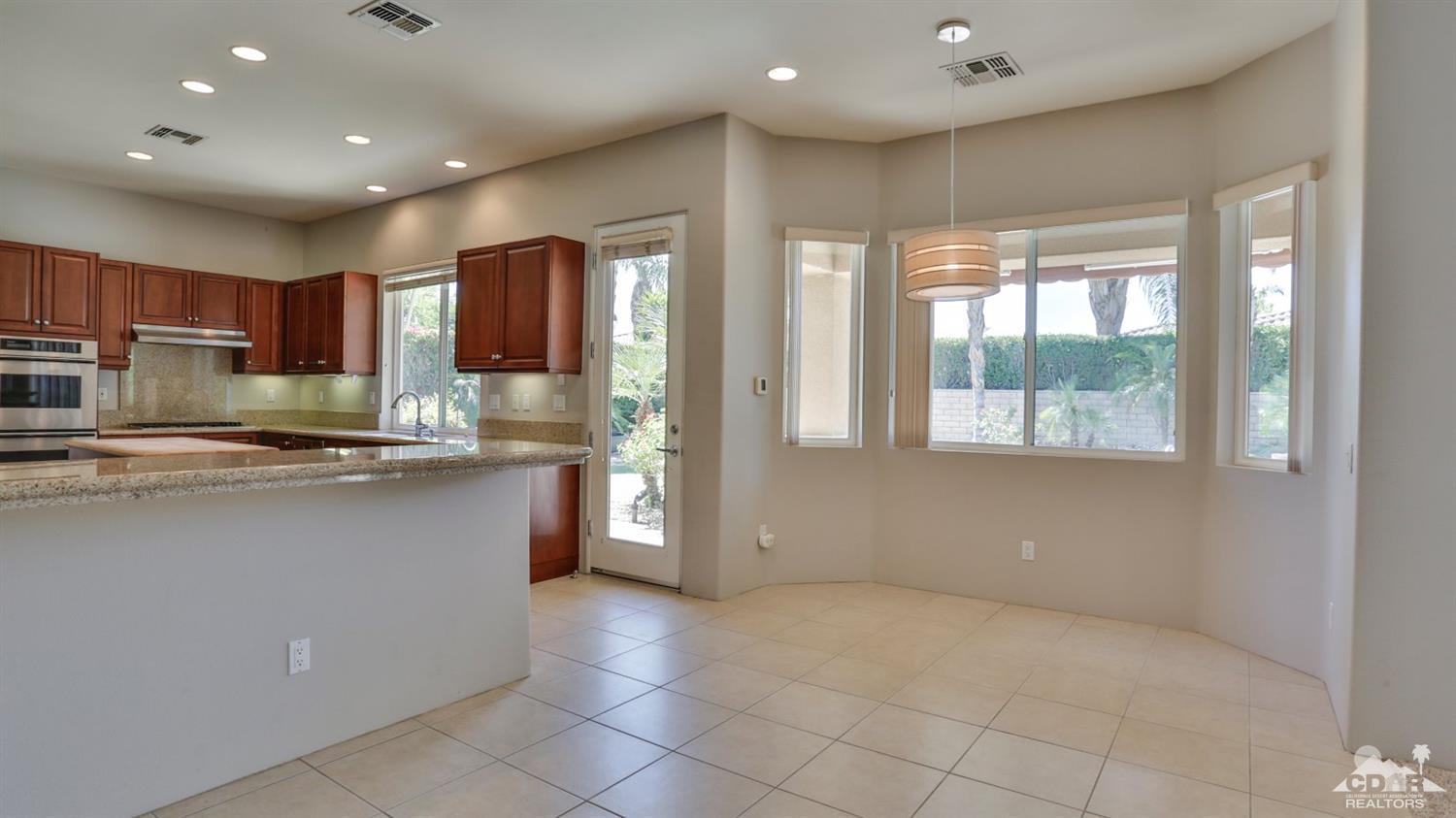 5 University Circle Rancho Mirage, CA 92270 - Photo 16 of 60 a kitchen with stainless steel appliances granite countertop a refrigerator and a stove top oven
