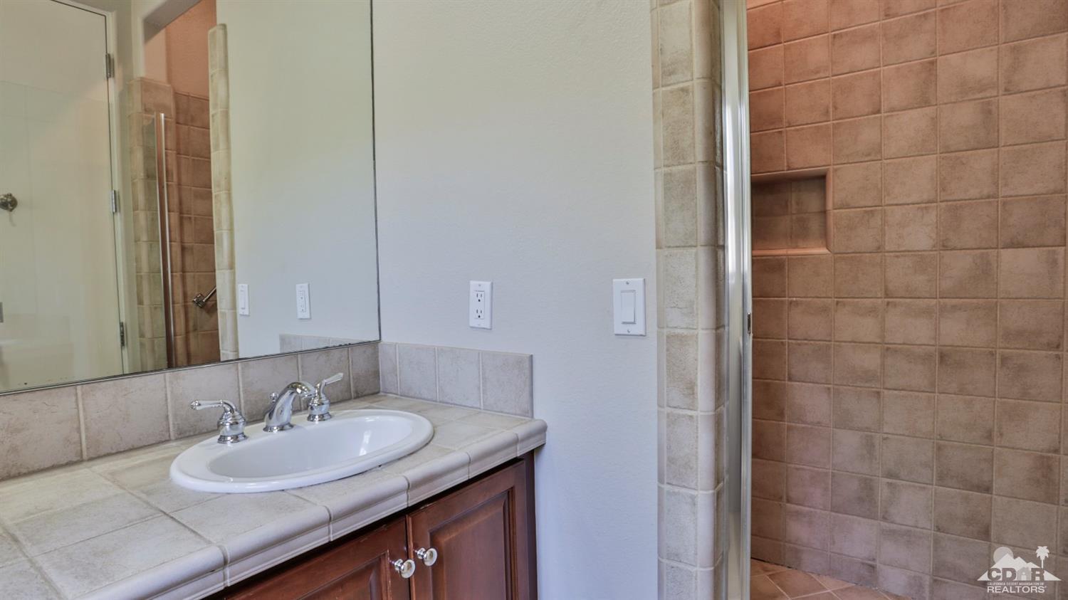 5 University Circle Rancho Mirage, CA 92270 - Photo 37 of 60 a bathroom with a granite countertop sink and a mirror