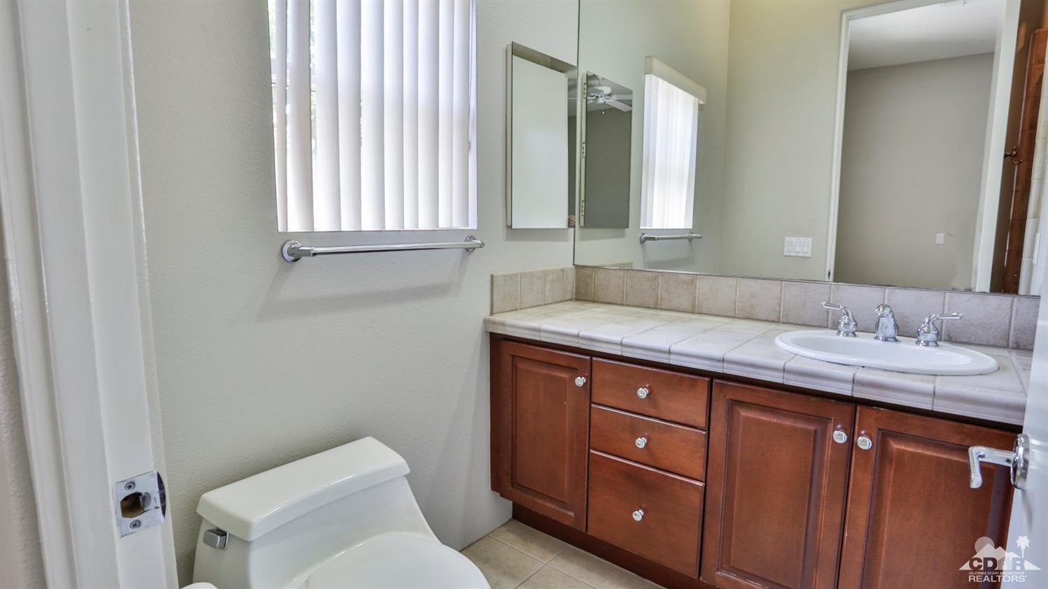 5 University Circle Rancho Mirage, CA 92270 - Photo 38 of 60 a bathroom with a granite countertop sink and a toilet