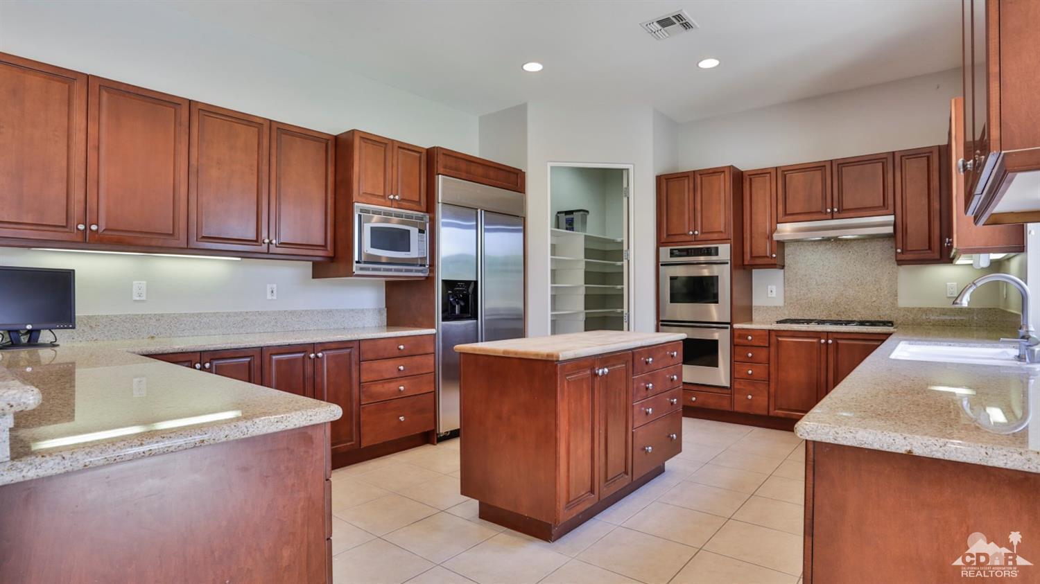 5 University Circle Rancho Mirage, CA 92270 - Photo 5 of 60 a kitchen with stainless steel appliances granite countertop a stove a sink and a refrigerator