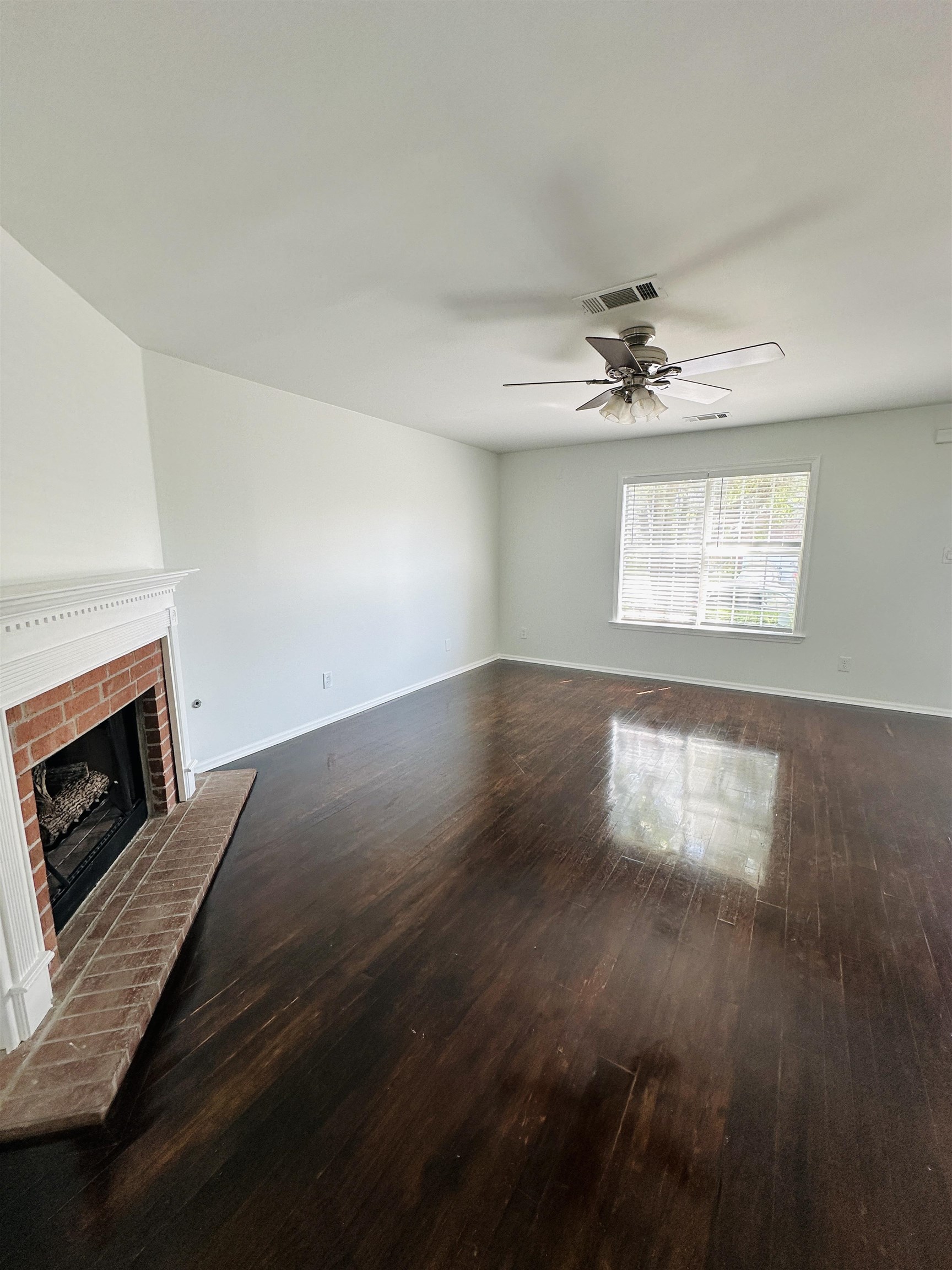 10006 Cameron Ridge Trail Memphis, TN 38016 - Photo 8 of 29 an empty room with wooden floor fireplace and windows