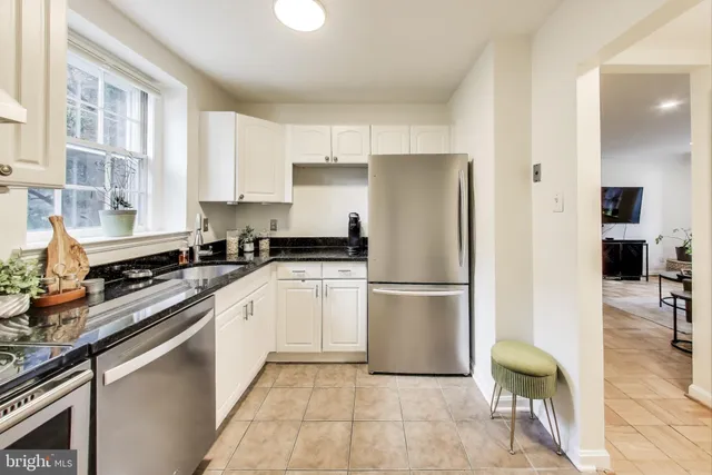 a kitchen with stainless steel appliances granite countertop a refrigerator sink and stove