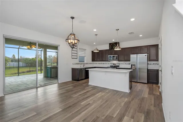 a kitchen with stainless steel appliances kitchen island a sink and a stove
