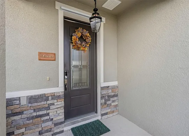 a view of a hallway with front door and wooden floor
