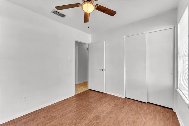 an empty room with a ceiling fan and a window