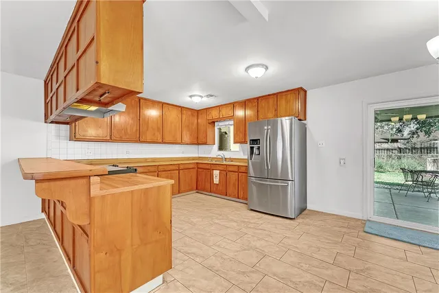 a kitchen with stainless steel appliances granite countertop a refrigerator and a sink