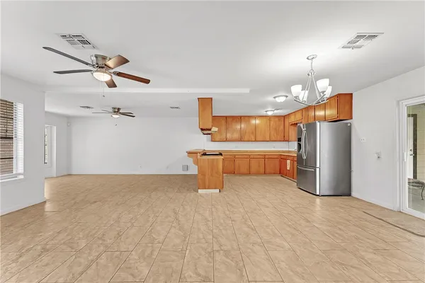 a kitchen with stainless steel appliances kitchen island a refrigerator and a fireplace