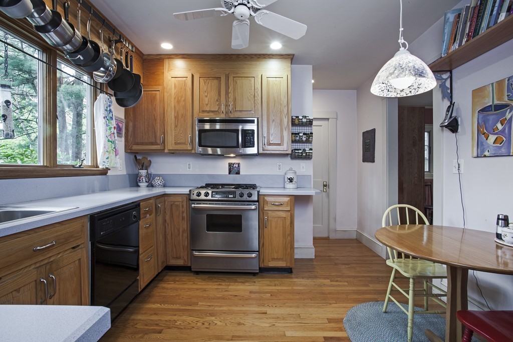 162 Waban Avenue Newton, MA 02468 - Photo 15 of 24 a kitchen with stainless steel appliances granite countertop a stove a sink dishwasher a dining table and chairs with wooden floor