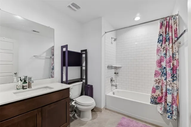 a bathroom with a bathtub shower sink vanity and toilet