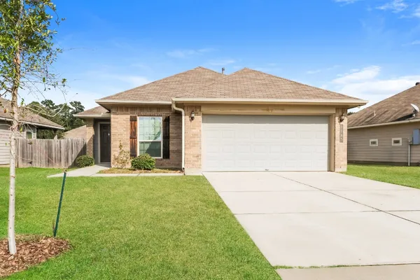 a front view of a house with a garden and yard