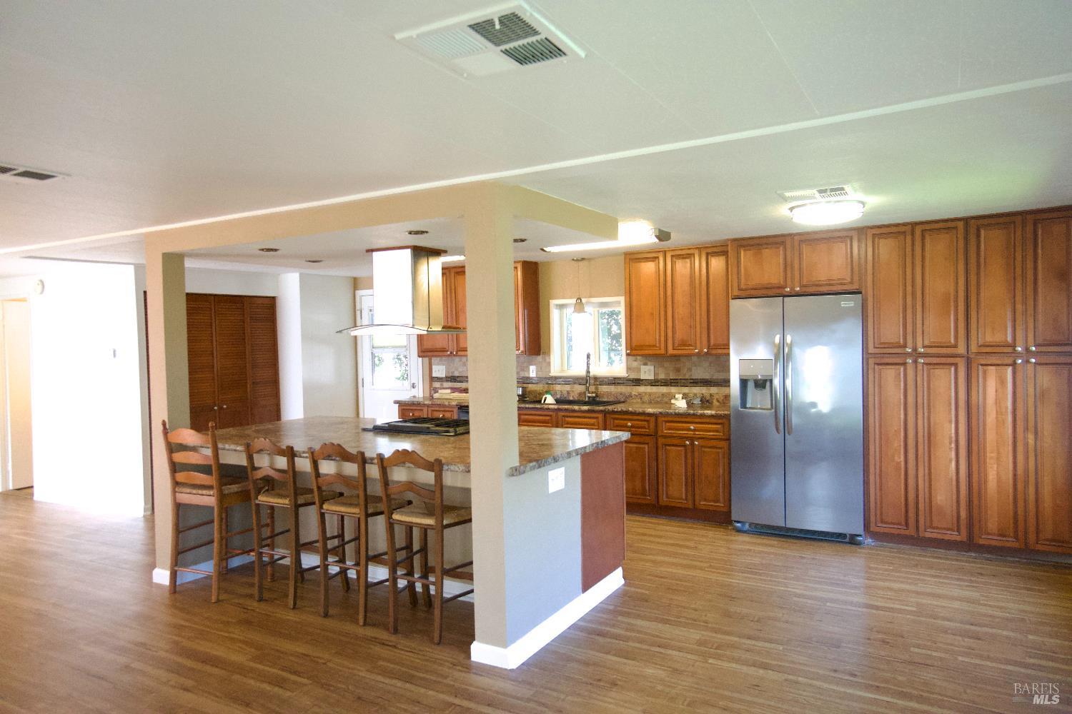 2412 Foothill Boulevard, Unit 124 Calistoga, CA 94515 - Photo 11 of 49 a kitchen with stainless steel appliances granite countertop a refrigerator and wooden floor