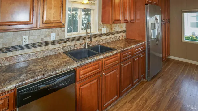 a kitchen with granite countertop a sink stove and cabinets