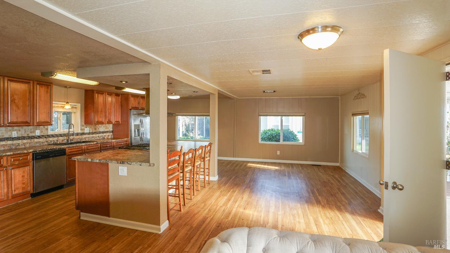 2412 Foothill Boulevard, Unit 124 Calistoga, CA 94515 - Photo 18 of 49 an open kitchen with wooden floor and stainless steel appliances