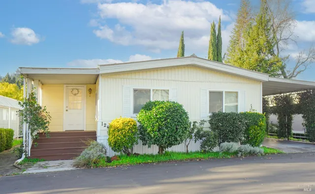 a view of a house with a yard and street