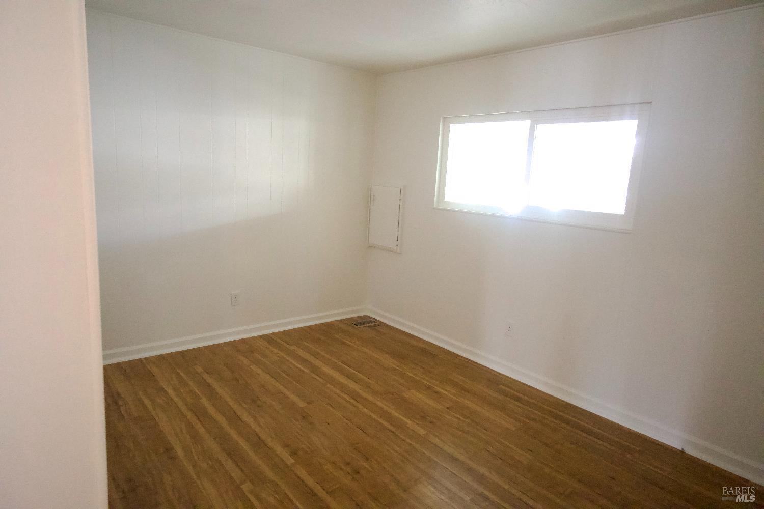 2412 Foothill Boulevard, Unit 124 Calistoga, CA 94515 - Photo 34 of 49 an empty room with wooden floor and windows