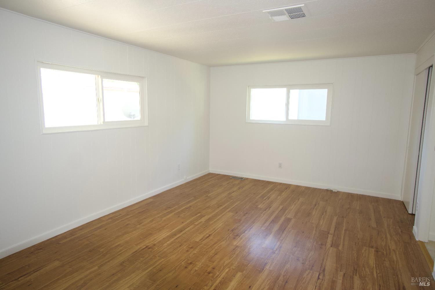 2412 Foothill Boulevard, Unit 124 Calistoga, CA 94515 - Photo 35 of 49 an empty room with wooden floor and windows