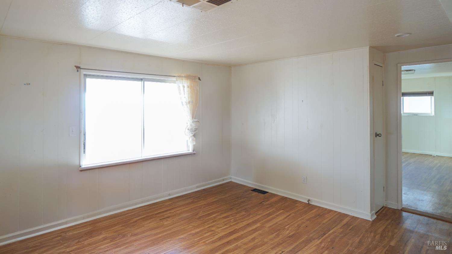 2412 Foothill Boulevard, Unit 124 Calistoga, CA 94515 - Photo 42 of 49 an empty room with wooden floor and windows