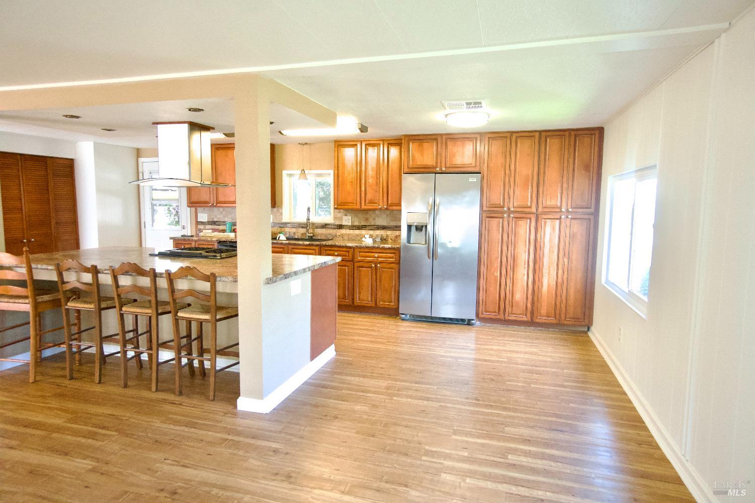 2412 Foothill Boulevard, Unit 124 Calistoga, CA 94515 - Photo 9 of 49 a view of a kitchen with kitchen island granite countertop wooden floor and stainless steel appliances