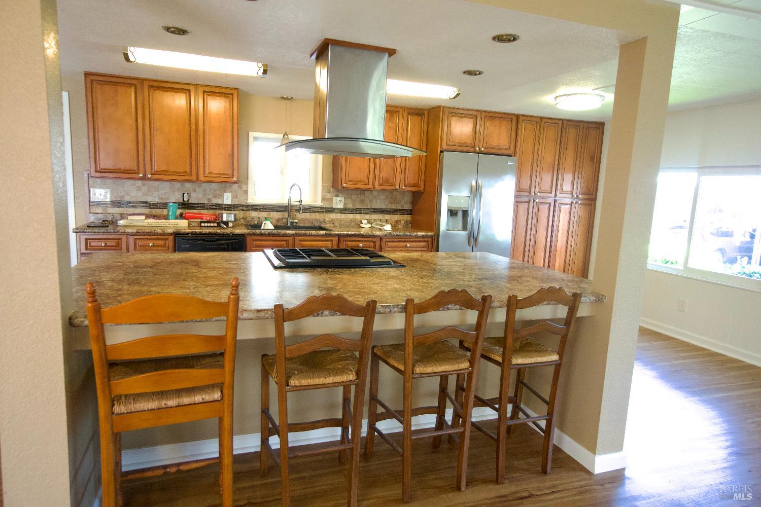 2412 Foothill Boulevard, Unit 124 Calistoga, CA 94515 - Photo 10 of 49 a kitchen with kitchen island granite countertop wooden floor cabinets and stainless steel appliances