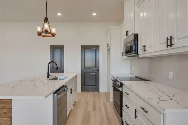 an empty room with wooden floor closet and windows