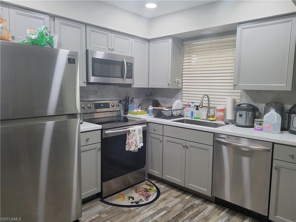 8518 Morris Road Fort Myers, FL 33967 - Photo 11 of 18 a kitchen with a refrigerator a stove a sink a microwave and cabinets