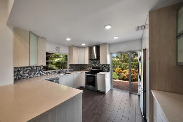 a kitchen with sink stove and refrigerator