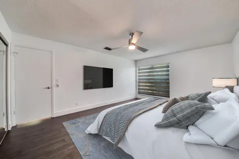 a bedroom with a large bed and a flat screen tv