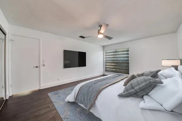 a bedroom with a large bed and a flat screen tv
