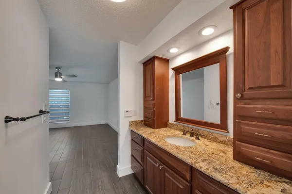 a bathroom with a granite countertop sink and a mirror