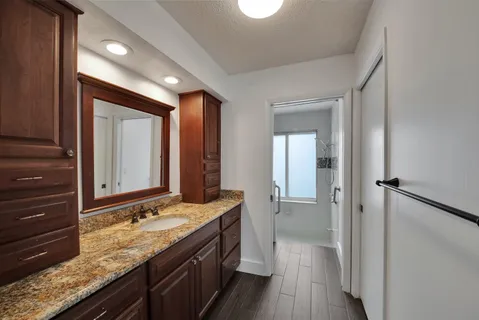 a bathroom with a granite countertop sink and a mirror