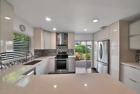 a kitchen with stainless steel appliances a refrigerator sink and stove